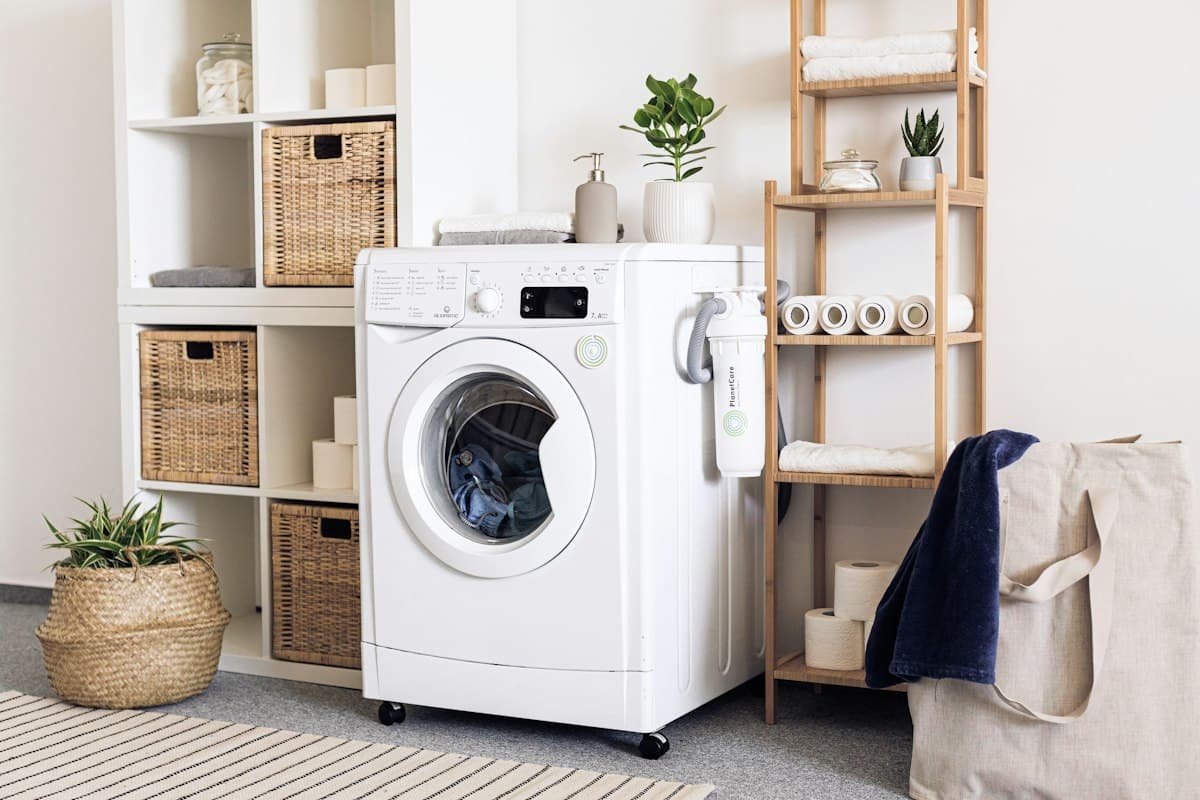 White front-load washing machine in a tidy laundry corner